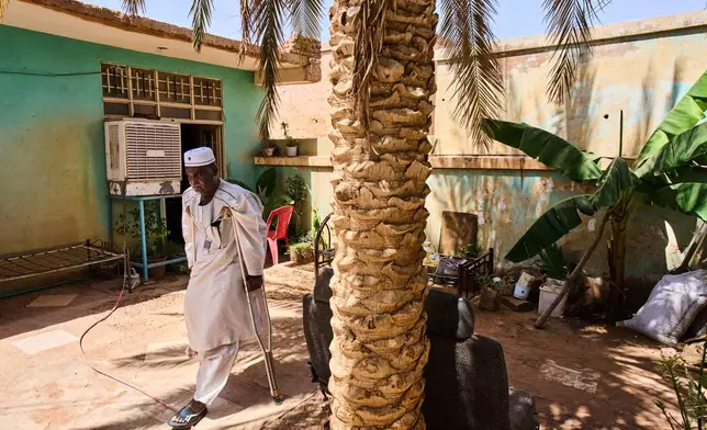 Tariq Abuzeid, 52, who lost his leg in a shelling attack, walks in the patio of his home in Omdurman, Sudan, Saturday, April 25, 2026. (AP Photo/Bernat Armangue)