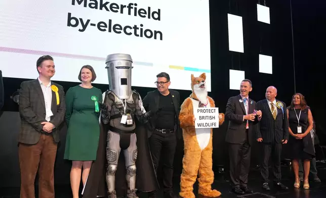 Labour party candidate Andy Burnham, center, stands with other candidates on the podium at the Edge Wigan, awaiting the Makerfield by-election result announcement in Wigan, England, Friday, June 19, 2026.(AP Photo/Jon Super)