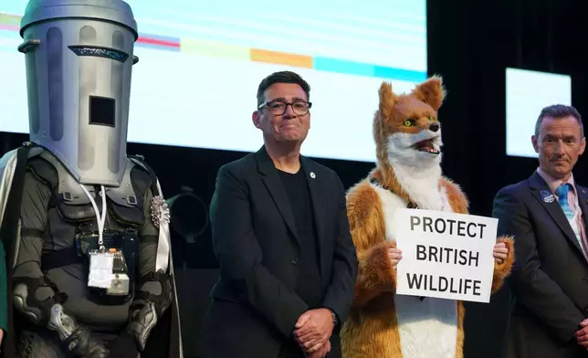 Labour party's Andy Burnham stands beside candidate Count Binface, left, and a candidate for Protect British Wildlife after winning the Makerfield by-election, paving the way for a leadership challenge against Prime Minister Sir Keir Starmer. in Wigan, England, Friday, June 19, 2026.(AP Photo/Jon Super)