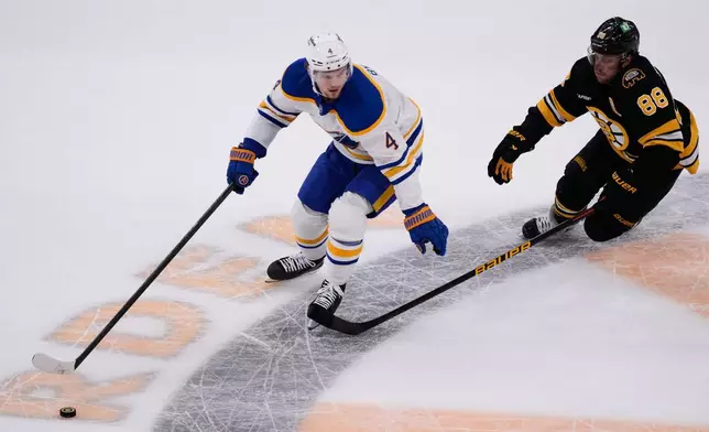 FILE - Buffalo Sabres defenseman Bowen Byram (4) controls the puck against Boston Bruins right wing David Pastrnak (88) during Game 3 of a first-round NHL hockey Stanley Cup playoff series, April 23, 2026, in Boston. (AP Photo/Charles Krupa, File)