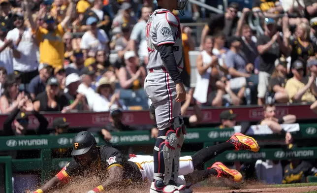 Pittsburgh Pirates' Oneil Cruz slides into home plate past Minnesota Twins catcher Alex Jackson scoring on Henry Davis' single in the fifth inning of a baseball game in Pittsburgh, Sunday, May 31, 2026. (AP Photo/Tom E. Puskar)