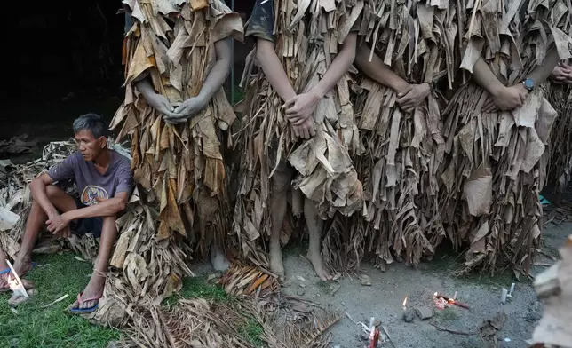 A Catholic devotee covered in mud and dried banana leaves participates in the mud people festival on the feast day of Saint John the Baptist at Bibiclat, Nueva Ecija province, northern Philippines on Wednesday, June 24, 2026. (AP Photo/Aaron Favila)