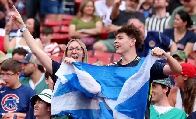 Fans of the Scotland men's soccer team sing and dance before a baseball game between the Boston Red Sox and the Texas Rangers, Sunday, June 14, 2026, in Boston. (AP Photo/Mark Stockwell)