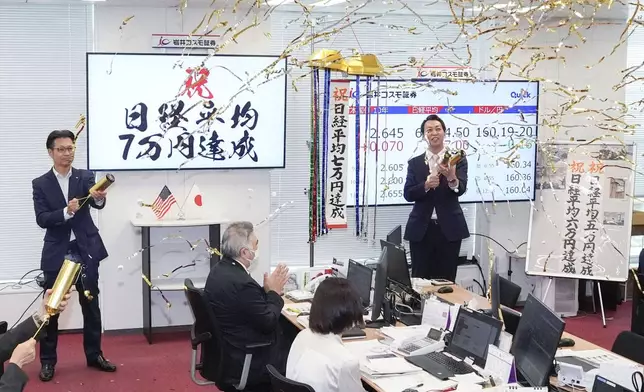 Employees of a securities company celebrate as Japan's benchmark Nikkei 225 topped 70,000 for the first time during trading hours in Tokyo Tuesday, June 16, 2026. A sign, left, reads " Congratulations. Nikkei index reached 70,000 yen." (Shinji Kouchi/Kyodo News via AP)