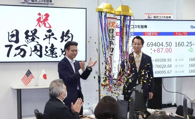 Employees of a securities company celebrate as Japan's benchmark Nikkei 225 topped 70,000 for the first time during trading hours in Tokyo Tuesday, June 16, 2026. A sign, left, reads "Congratulations. Nikkei index reached 70,000 yen." (Shinji Kouchi/Kyodo News via AP)