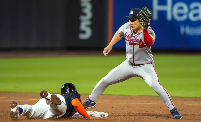 New York Mets' Marcus Semien, left, reach second base safe as Atlanta Braves' a-Seong Kim keeps an eye on him during the second inning of a baseball game, Friday, June 12, 2026, in New York. (AP Photo/Eduardo Munoz Alvarez)