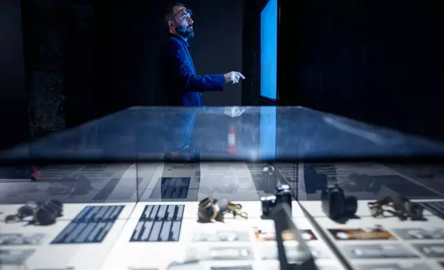 Cornel Constantin Ilie, manager of the National History Museum of Romania looks at a display during the opening of the "A.REST 1989 — The Securitate Video Archive" exhibition, at the National History Museum of Romania, in Bucharest, Romania, Tuesday, June 16, 2026. (AP Photo/Andreea Alexandru)