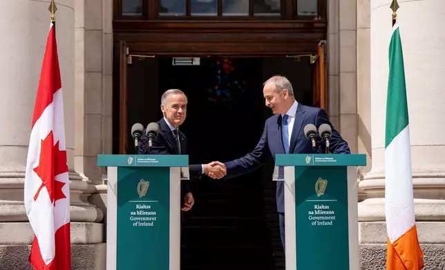 Prime Minister Mark Carney, left, shakes hands with Micheal Martin, Ireland's head of government, after giving remarks at the Government Buildings in Dublin, Ireland, on Saturday, June 13, 2026. (Christopher Katsarov /The Canadian Press via AP)