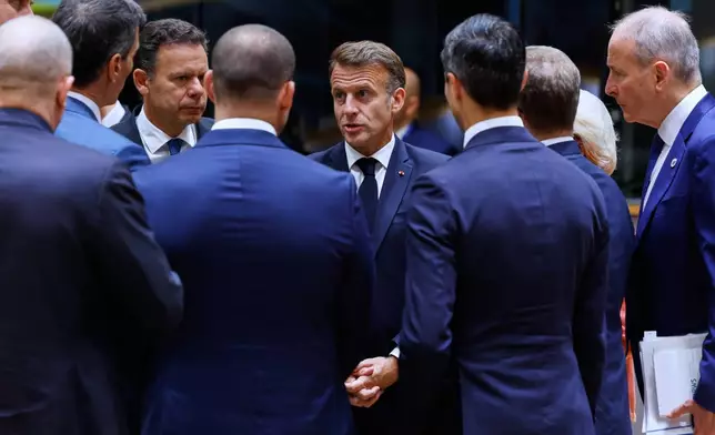 French President Emmanuel Macron, center, talks to other EU leaders during a round table meeting at the EU summit in Brussels, Friday, June 19, 2026. (AP Photo/Geert Vanden Wijngaert)