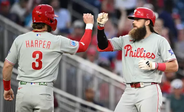 Philadelphia Phillies' Brandon Marsh, right, celebrates his two-run home run with Bryce Harper (3) during the sixth inning of a baseball game against the Washington Nationals, Thursday, June 25, 2026, in Washington. (AP Photo/Nick Wass)