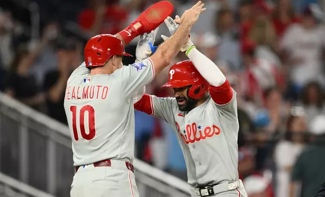 Philadelphia Phillies' Derek Hill, right, celebrates his two-run home run with J.T. Realmuto, left, during the ninth inning of a baseball game against the Washington Nationals, Thursday, June 25, 2026, in Washington. (AP Photo/Nick Wass)