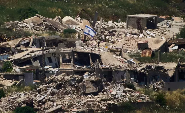An Israeli flag hangs on a destroyed building in southern Lebanon as seen from northern Israel, Thursday June 4, 2026. (AP Photo/Ariel Schalit)