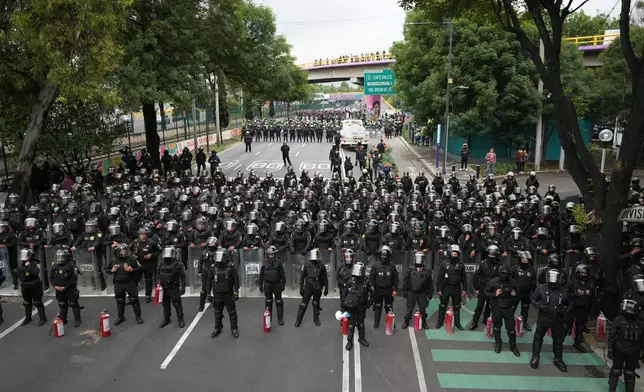 Police block an avenue to prevent protesting teachers from marching to the stadium that will host the opening match of the FIFA World Cup in Mexico City, Tuesday, June 9, 2026. (AP Photo/Eduardo Verdugo)