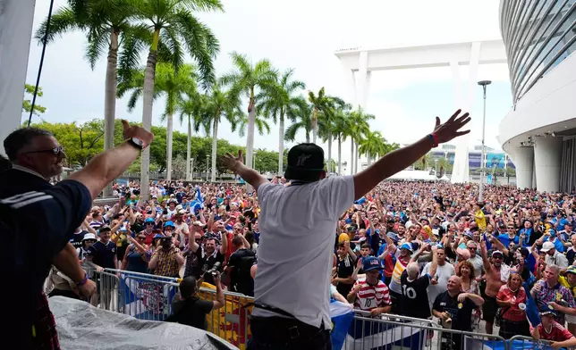 Scotland soccer fans sing along to music before a baseball game between the Miami Marlins and the Texas Rangers as part of the Tartan Army march, Monday, June 22, 2026, in Miami. (AP Photo/Lynne Sladky)
