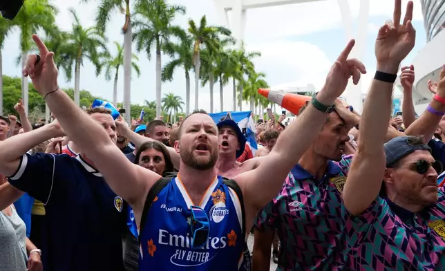 Scotland soccer fans sing along to music before a baseball game between the Miami Marlins and the Texas Rangers as part of the Tartan Army march, Monday, June 22, 2026, in Miami. (AP Photo/Lynne Sladky)