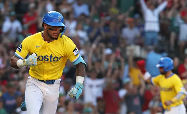 Boston Red Sox's Ceddanne Rafaela pumps his fist as he heads for first base with a seventh-inning two-run single during a baseball game against the Texas Rangers, Saturday, June 13, 2026,,,,,,, in Boston. (AP Photo/Jim Davis)
