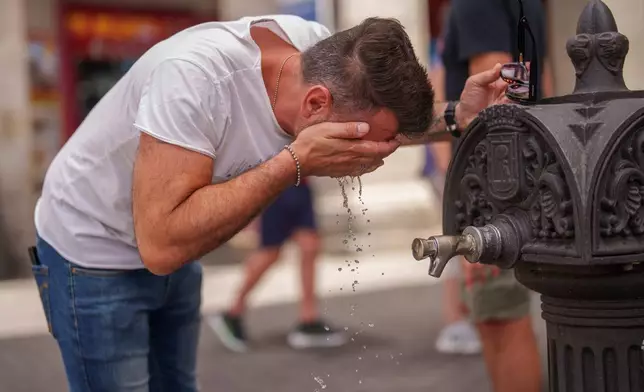 FILE - A man cools off in a fountain during a hot and sunny day of summer in Madrid, Spain, July 19, 2023. (AP Photo/Manu Fernandez, File)