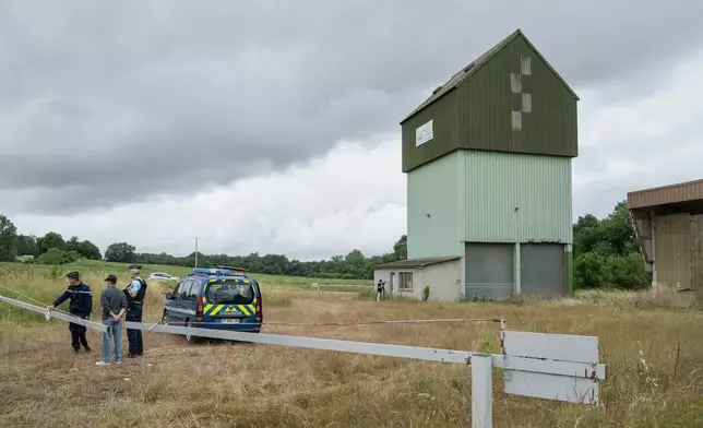French police guard a farm silo where a body was found yesterday during the search to find missing 11 year-old girl Lyhanna in Puycasquier, southwestern France, Friday, June,5, 2026. (AP Photo/Frederic Lancelot)