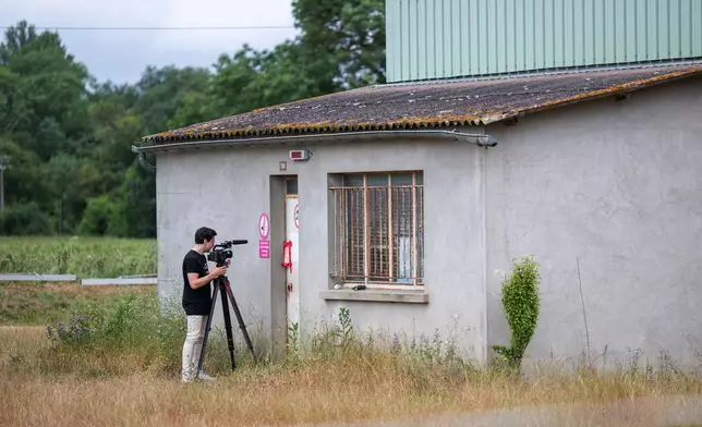 A videographer films the entrance of a farm silo where a body was found yesterday during the search to find missing 11 year-old girl Lyhanna in Puycasquier, southwestern France, Friday, June,5, 2026. (AP Photo/Frederic Lancelot)
