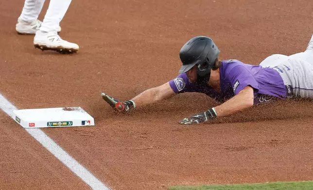 Colorado Rockies' Kyle Karros (12) slides into third base off a single hit by Colorado Rockies first baseman TJ Rumfield (7) during the first inning of a baseball game Friday, June 12, 2026, in Las Vegas. (AP Photo/Caroline Brehman)