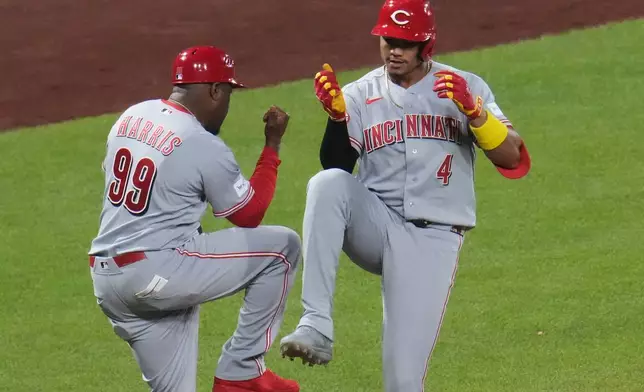Cincinnati Reds' Noelvi Marte (4) celebrates with Cincinnati Reds third base coach Willie Harris (99) as he rounds third base after hitting a two-run home run off Pittsburgh Pirates pitcher Mason Montgomery during the eighth inning of a baseball game in Pittsburgh, Friday, June 26, 2026. (AP Photo/Gene J. Puskar)