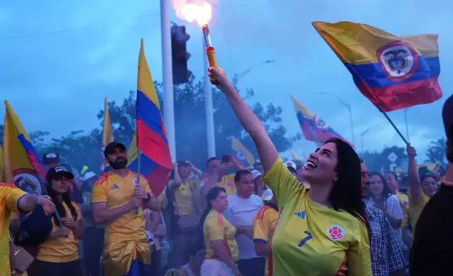 A supporter of presidential candidate Abelardo de la Espriella of the opposition Defenders of the Motherland movement light a flare at a celebration rally after polls closed in the runoff election in Barranquilla, Colombia, Sunday, June 21, 2026. (AP Photo/Rodrigo Abd)