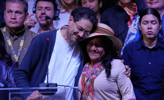 Presidential candidate Ivan Cepeda of the ruling Historic Pact coalition embraces his vice-presidential running mate, Aida Quilcue, during an election night appearance after election results showed him trailing in Bogota, Colombia, Sunday, June 21, 2026. (AP Photo/Fernando Vergara)