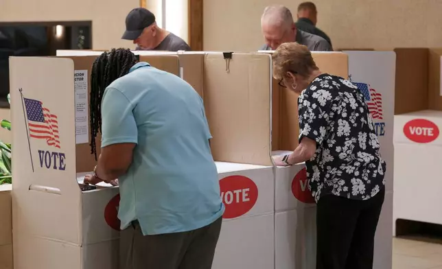 Voters mark ballots at a polling location inside the Shoppes at Northpark mall, Tuesday, June 16, 2026, in Oklahoma City. (AP Photo/Nate Billings)