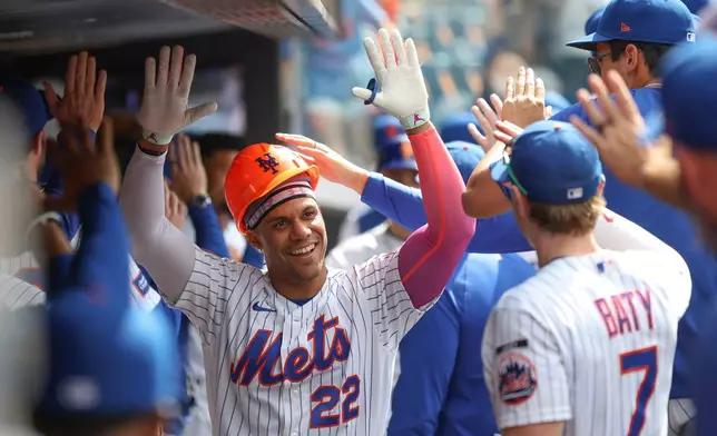 New York Mets' Juan Soto (22) celebrates in the dugout after his grand slam during the sixth inning of a baseball game against the Miami Marlins, Sunday, May 31, 2026, in New York. (AP Photo/Heather Khalifa)