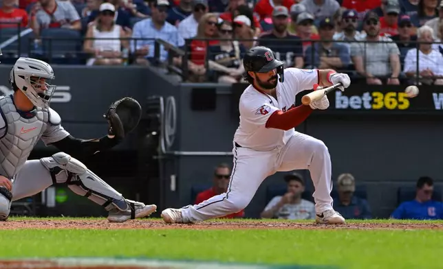 Cleveland Guardians' Austin Hedges, right, lays down a bunt as Detroit Tigers' Dillon Dingler watches during the fourth inning of a baseball game, Saturday, June 13, 2026, in Cleveland. (AP Photo/Phil Long)