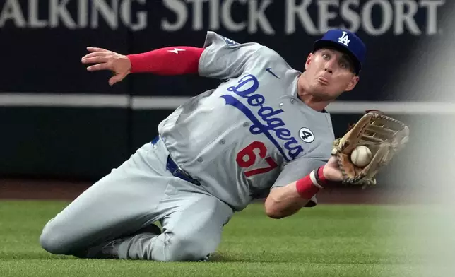 Los Angeles Dodgers left fielder Ryan Ward makes the sliding catch for an out on a ball hit by Arizona Diamondbacks' Nolan Arenado in the fifth inning of a baseball game, Tuesday, June 2, 2026, in Phoenix. (AP Photo/Rick Scuteri)