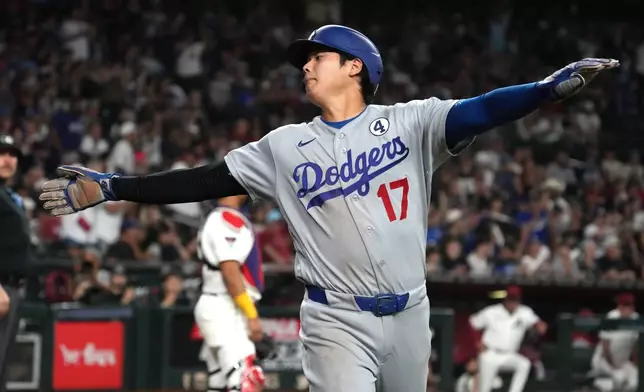 Los Angeles Dodgers' Shohei Ohtani reacts after scoring on a single hit by Mookie Betts against the Arizona Diamondbacks in the seventh inning of a baseball game, Tuesday, June 2, 2026, in Phoenix. (AP Photo/Rick Scuteri)