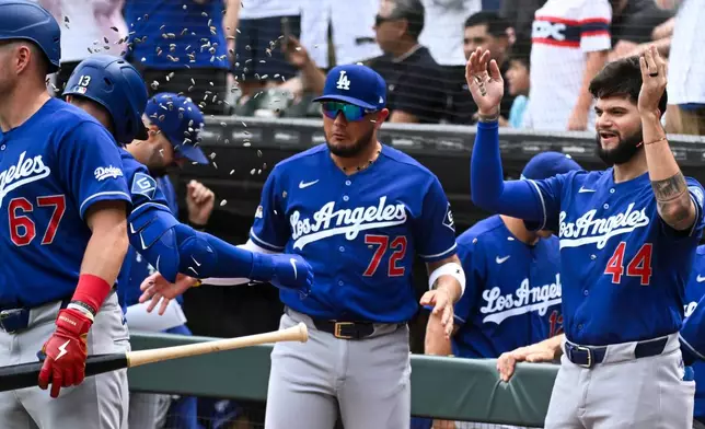Los Angeles Dodgers' Max Muncy (13) has sunflower seeds thrown on him by teammates after he hit a two-run home run during the first inning of a baseball game against the Chicago White Sox, Saturday, June 13, 2026, in Chicago. (AP Photo/Matt Marton)
