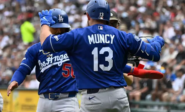 Los Angeles Dodgers' Max Muncy (13) celebrates with Mookie Betts (50) after they scored on Muncy's two-run home run during the first inning of a baseball game against the Chicago White Sox, Saturday, June 13, 2026, in Chicago. (AP Photo/Matt Marton)