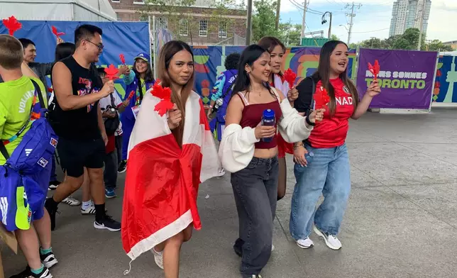 Attendees show off the "Canadian clappers" they just received at the FIFA Fan Festival Wednesday, June 24, 2026, in Toronto. (AP Photo/Mike Householder)