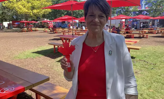 Sharon Bollenbach, the City of Toronto's World Cup executive director, holds a "Canadian clapper" at the FIFA Fan Festival Tuesday, June 23, 2026, in Toronto. (AP Photo/Mike Householder)