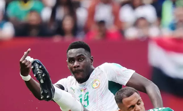 Senegal's Moussa Niakhate, left, kicks the ball over Iraq's Ali al-Hamadi (9) during the World Cup Group I soccer match between Senegal and Iraq in Toronto, Friday, June 26, 2026. (Nathan Denette/The Canadian Press via AP)