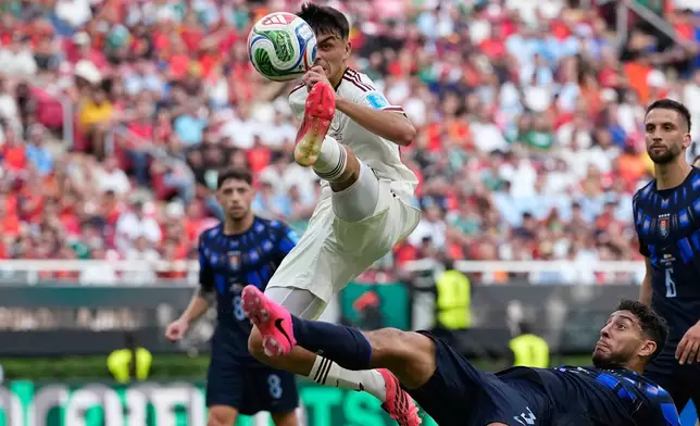 Spain's Pedri, top, and Uruguay's Sebastian Caceres vie for the ball during the World Cup Group H soccer match between Uruguay and Spain in Zapopan, near Guadalajara, Mexico, Friday, June 26, 2026. (AP Photo/Natacha Pisarenko)