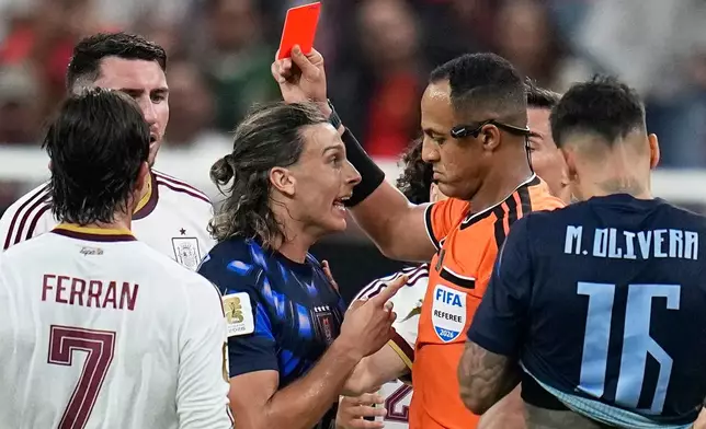 Referee Ismail Elfath shows a red card to Uruguay's Agustin Canobbio during the World Cup Group H soccer match between Uruguay and Spain in Zapopan, near Guadalajara, Mexico, Friday, June 26, 2026. (AP Photo/Ricardo Mazalan)
