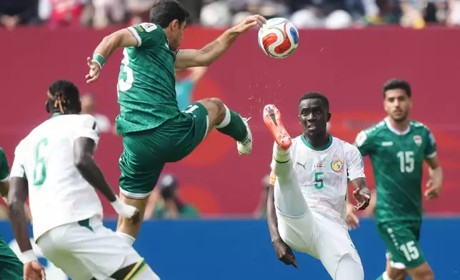 Iraq's Ali Yousif, top, and Senegal's Idrissa Gueye (5) battle for the ball during the World Cup Group I soccer match between Senegal and Iraq in Toronto, Friday, June 26, 2026. (Nathan Denette/The Canadian Press via AP)