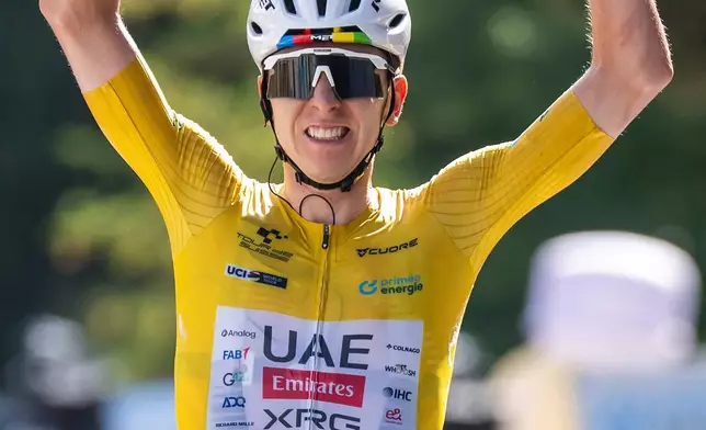 The winner of the stage Tadej Pogacar, of Slovenia, celebrates as he crosses the finish of the fifth and final stage, a 151 km race with start and finish in Villars-sur-Ollon, at the 89th Tour de Suisse UCI World Tour cycling race, Sunday, June 21, 2026. (Gian Ehrenzeller/Keystone via AP)