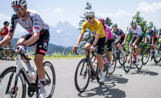 Tadej Pogacar, center, from Slovenia of UAE Team Emirates-XRG competes during the fifth and final stage, a 151 km race with start and finish in Villars-sur-Ollon, Switzerland, at the 89th Tour de Suisse UCI World Tour cycling race, on Sunday, June 21, 2026. (Gian Ehrenzeller/Keystone via AP)