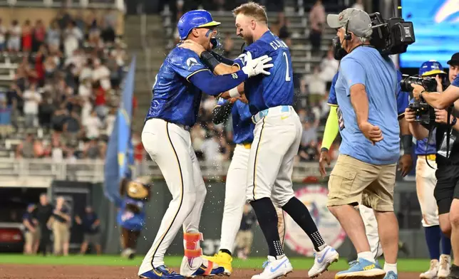 Minnesota Twins' Royce Lewis, left, celebrates with Kody Clemens (2) after hitting a walkoff single against the Colorado Rockies during the 10th inning of a baseball game Friday, June 26 2026, in Minneapolis. (AP Photo/Craig Lassig)