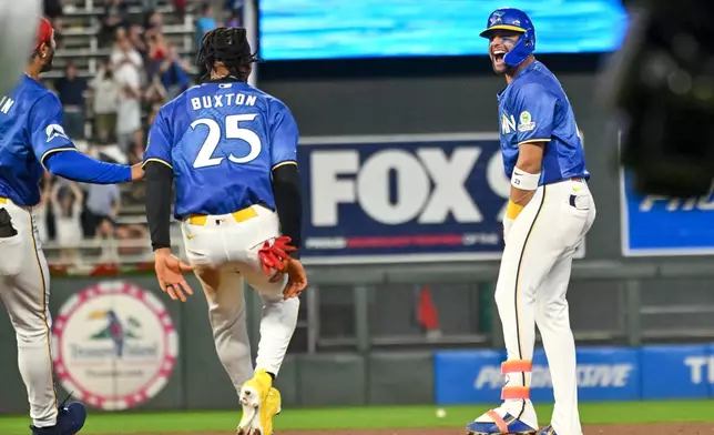 Minnesota Twins' Royce Lewis, right, celebrates with Byron Buxton (25) after hitting a walkoff single against the Colorado Rockies during the 10th inning of a baseball game Friday, June 26 2026, in Minneapolis. (AP Photo/Craig Lassig)