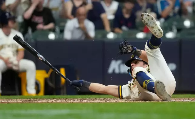 Milwaukee Brewers' Sal Frelick falls to the ground after taking a pitch to draw a walk during the sixth inning of a baseball game against the Cincinnati Reds, Monday, June 29, 2026, in Milwaukee. (AP Photo/Aaron Gash)