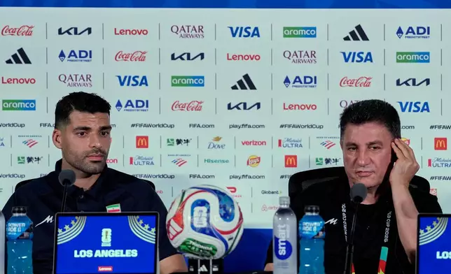 Iran head coach Amir Ghalehnoy, right, and player Mehdi Taremi listens to a question during a press conference ahead of their FIFA World Cup match against New Zealand in Inglewood, Calif., near Los Angeles, Sunday, June 14, 2026. (AP Photo/Andre Penner)