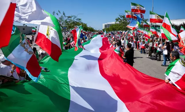 People carry a giant Iranian flag during a protest in reaction to FIFA's ban of Iran's pre-revolutionary flag inside World Cup stadiums Sunday, June 7, 2026, in Inglewood, Calif. (AP Photo/Benjamin Hanson)
