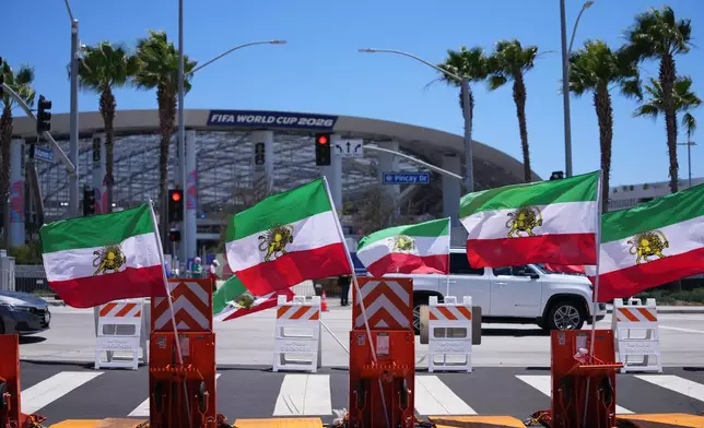Pre-revolutionary Iranian flags stand during a protest outside Los Angeles Stadium before the World Cup Group G soccer match between Iran and New Zealand in Inglewood, Calif., near Los Angeles, Monday, June 15, 2026. (AP Photo/Jae C. Hong)