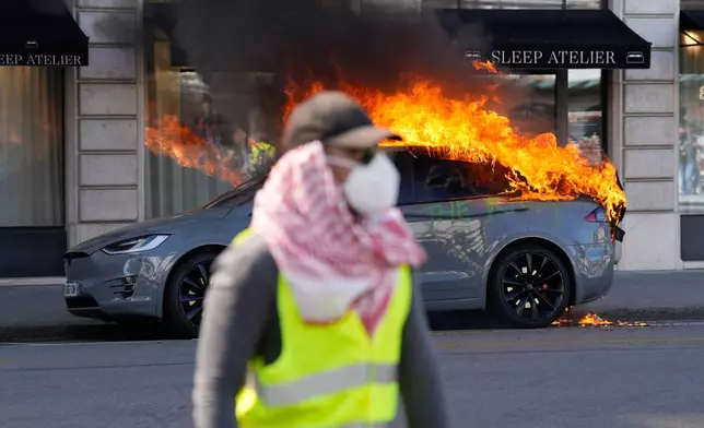 A car burns during a "No G7" demonstration in Geneva, Switzerland, Sunday, June 14, 2026, ahead of the G7 summit scheduled to take place June 15-17. (AP Photo/Baz Ratner)