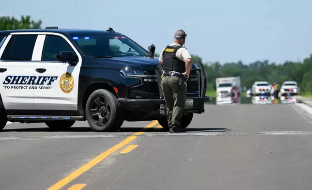 A Bates County Sheriff's Deputy mans a roadblock outside the scene of a plane crash at Butler Memorial Airport in Butler, Mo., Sunday, June 14, 2026. (AP Photo/Reed Hoffmann)